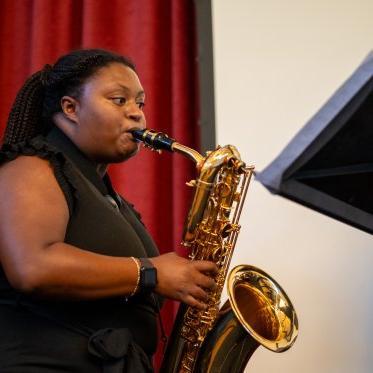 Student playing the saxophone at the 2024 Student Research Conference